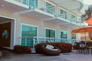um edifício com um pátio com cadeiras e um guarda-sol em Hotel Paradiso del Sol em Cabo Frio