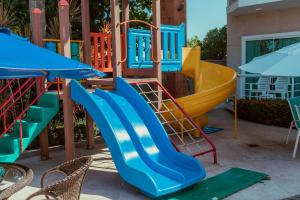 un parque infantil con un tobogán azul y amarillo en Hotel Paradiso del Sol, en Cabo Frío