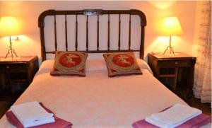 a bedroom with a bed with two lamps and towels at Cal Gravat in Montsonis