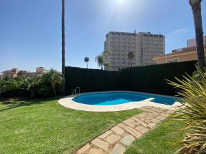 una piscina en un patio junto a un seto en Apartamentos Villa Torreblanca, en Fuengirola