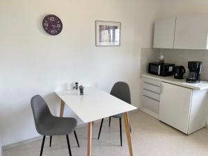 une cuisine avec une table blanche et deux chaises dans l'établissement Landvilla Dagobert, à Malsfeld