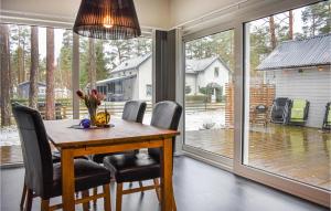 a dining room with a table and chairs and a large window at Nice Home In hus With Kitchen in Åhus