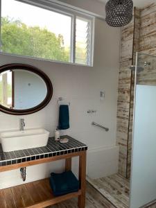a bathroom with a sink and a mirror and a shower at Auka Boutique in Urubamba