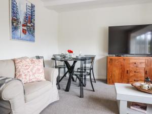 a living room with a table and a tv at Valley View in Teignmouth
