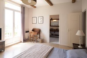 a bedroom with a bed and a desk and a window at Mas des Prevots B&B in Noves +20 photos