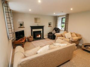 a living room with two couches and a fireplace at Garth Gill in Sedbergh