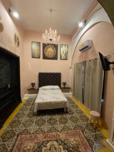 a bedroom with a bed and a chandelier at Hotel Edzna in Campeche