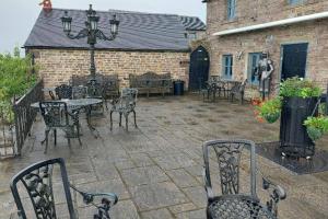 a patio with chairs and a table and a building at 2 Bed Flat - Sleeps 4 - Patio - Parking - Wifi in Buxton