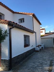 ein weißes Gebäude mit zwei Fenstern und einer Terrasse in der Unterkunft Meublé trois étoiles au premier étage d’une maison typique in Saint-Cyprien + 5 Fotos