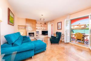 ein Wohnzimmer mit einem blauen Sofa und einem Tisch in der Unterkunft Villa Malena in Llucmajor