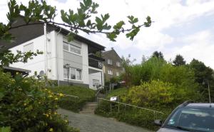 a house on a hill with a car parked in front at Ferienwohnung-Eifelpanorama in Gönnersdorf