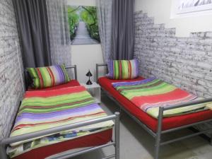 two beds in a room with colorful striped pillows at Ferienwohnung-Eifelpanorama in Gönnersdorf