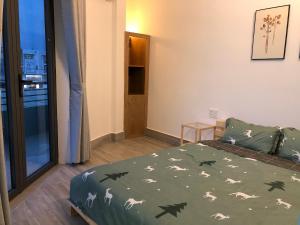 1 dormitorio con 1 cama con edredón verde con lobos en STAY hostel - 300m from the ferry en Rạch Giá