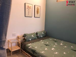 1 dormitorio con 1 cama y 3 cuadros en la pared en STAY hostel - 300m from the ferry, en Rạch Giá