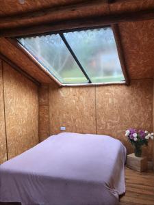 a bedroom with a bed in a room with a window at La Casa de las Estrellas in Suesca