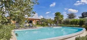 basen z krzesłami i dom w obiekcie Luxury Sicily Villas by Geocharme w mieście Castelvetrano Selinunte