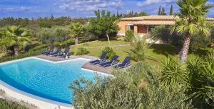 basen z krzesłami i dom w obiekcie Luxury Sicily Villas by Geocharme w mieście Castelvetrano Selinunte