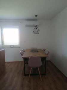 comedor con mesa, sillas y ventana en Apartment Sunset, en Maribor
