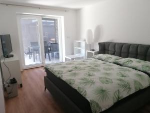 a bedroom with a bed and a sliding glass door at Apartment Sunset in Maribor