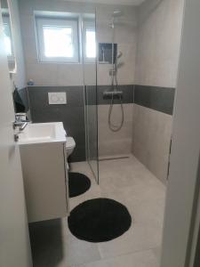 uma casa de banho com um chuveiro, um lavatório e um WC. em Apartment Sunset em Maribor