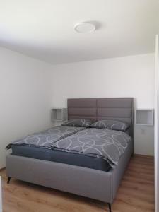 um quarto com uma cama num quarto branco em Apartment Sunset em Maribor