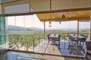 Habitación con mesas y sillas en un balcón con vistas. en Evim Zeytinlik Pension, en Gülpınar