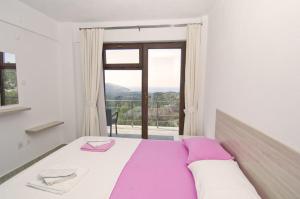- une chambre avec un lit et une grande fenêtre dans l'établissement Evim Zeytinlik Pension, à Gülpınar