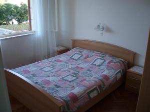 een slaapkamer met een bed met een quilt bij Apartment Vjera in Korčula