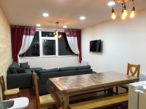 uma sala de estar com um sofá e uma mesa em appartement 12 couchages proche piste ski et de randonnées du lioran em Le Lioran