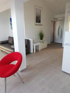 a living room with a red chair and a couch at Apartmani Deluxe in Jasenice