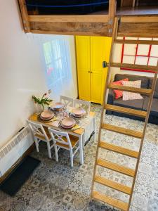 a dining room with a table and a bunk bed at Domek TRZY BABY in Dołgie
