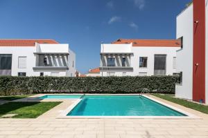 een zwembad voor twee gebouwen bij Caminho da Praia in Ferrel