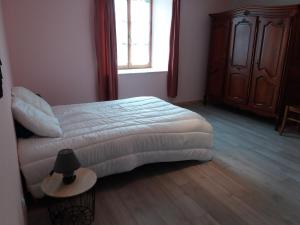 um quarto com uma cama, uma mesa e uma janela em Appartement meublé agréable au cœur du massif du Jura em Malpas