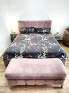 a large bed with a pink ottoman in a bedroom at Villa Bambooka in Bar