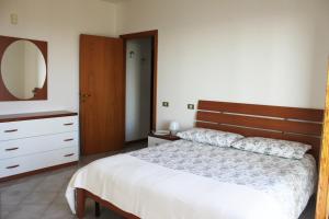 um quarto com uma cama, uma cómoda e um espelho em Abbadia 14 em Osimo