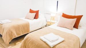 dos camas sentadas una al lado de la otra en una habitación en Casa Huesped Mendoza Modernismo y confort en este hermoso apartamento !! en Mendoza