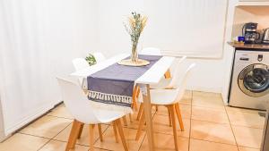 mesa de comedor con sillas blancas y mantel azul en Casa Huesped Mendoza Modernismo y confort en este hermoso apartamento !! en Mendoza