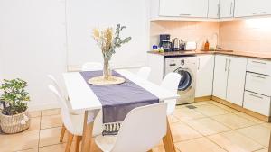 cocina con mesa y sillas blancas en Casa Huesped Mendoza Modernismo y confort en este hermoso apartamento !! en Mendoza