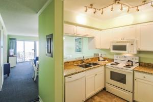 a kitchen with white cabinets and a sink at A Place at the Beach III, a VRI resort in Atlantic Beach