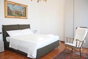 a bedroom with a bed and a chair at Villa Regina Elena Vittoria in Porcari +74 photos
