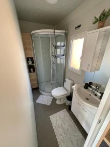 een badkamer met een douche, een toilet en een wastafel bij H&S Mobile Home in Privlaka