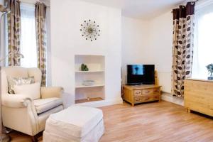 a living room with a chair and a tv at Fabulous 2 Bedroom Apartment in London Bridge in London
