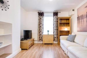 a living room with a couch and a tv at Fabulous 2 Bedroom Apartment in London Bridge in London