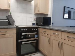 una cucina con piano cottura nero e forno a microonde di Entire Rental, Easy Reach to Etihad Stadium a Manchester