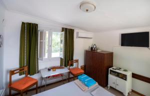 una camera con due sedie, un tavolo e una TV di Anni's cozy apartments 50m from the beach a Agia Triada