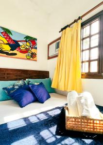 Habitación con cama y cortina amarilla en Pousada Harmonia, en Tamandaré