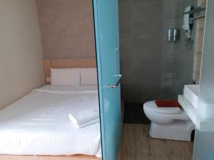 a bathroom with a bed and a toilet and a shower at Kyoto Boutique Hotel in Johor Bahru