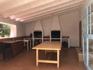 um quarto amplo com uma mesa e uma lareira em Cortijo El Álamo em Vélez Blanco