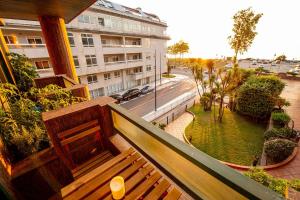 - un balcon avec un banc en bois dans un bâtiment dans l'établissement Apartamento playa de Samil, à Vigo