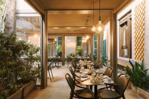 a restaurant with tables and chairs and plants at Sonder Missori in Milan